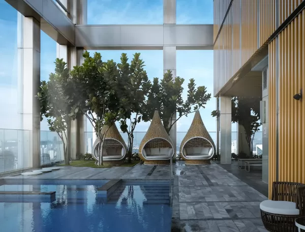 Luxury spa pool interior with view of city and row of whicker teepee chairs 