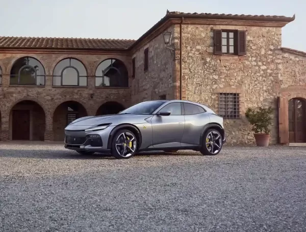 Matte grey Ferrari Purosangue outside luxury home