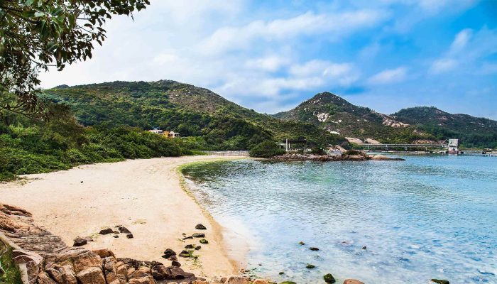 Golden beaches with blue sea surrounded by green hills