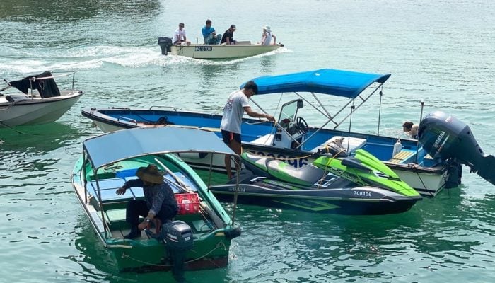 Small boats, dinghies and jet ski's powered by men on the lake