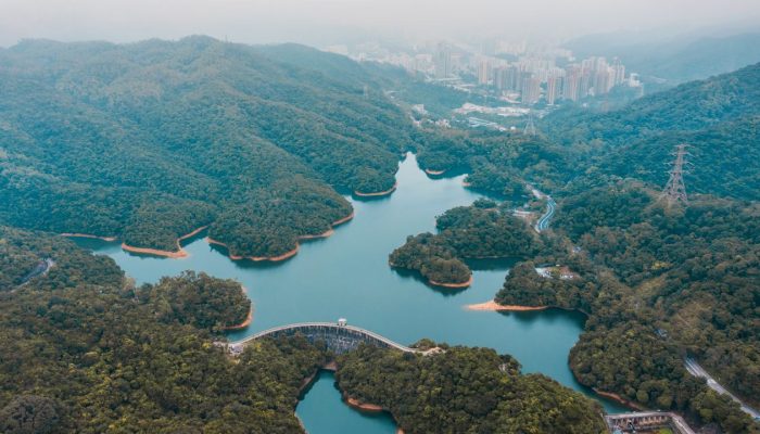 Birds eye view of grand lake of Wilson trial surrounded by green bushes and trees towards Kong Kong city