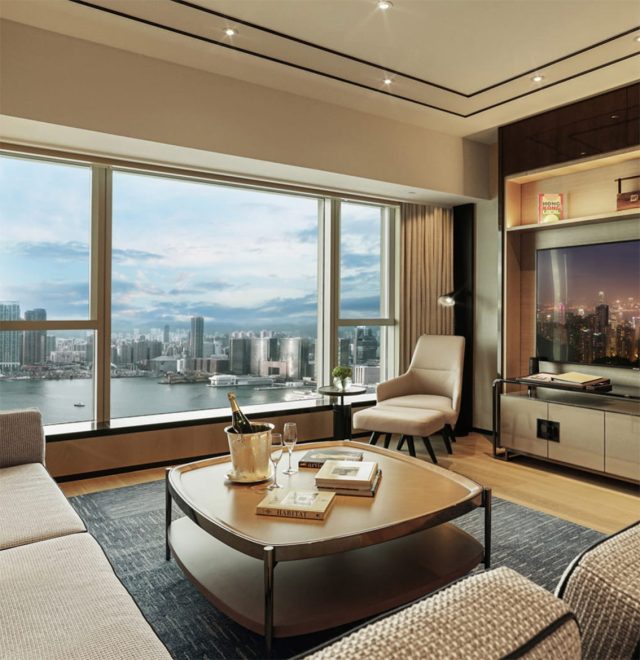 Luxury apartment hotel living room with books and champagne overlooking a view of skyline of Hong Kong