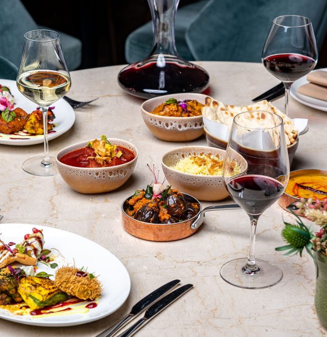 Selection of luxurious fine dining plates served with red and white wine.
