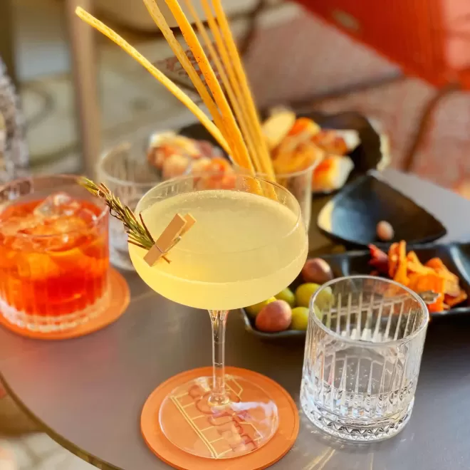 Table with martini and negroni cocktails and a selection of mixed olives and bar snacks
