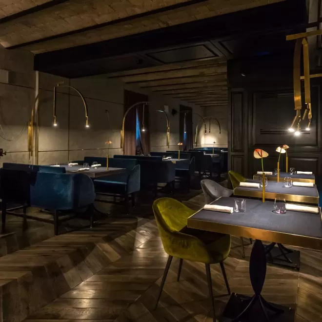 Insight dim-lighted restaurant with herringbone floor, lime and blue velour dining chairs at Ristorante All Orla